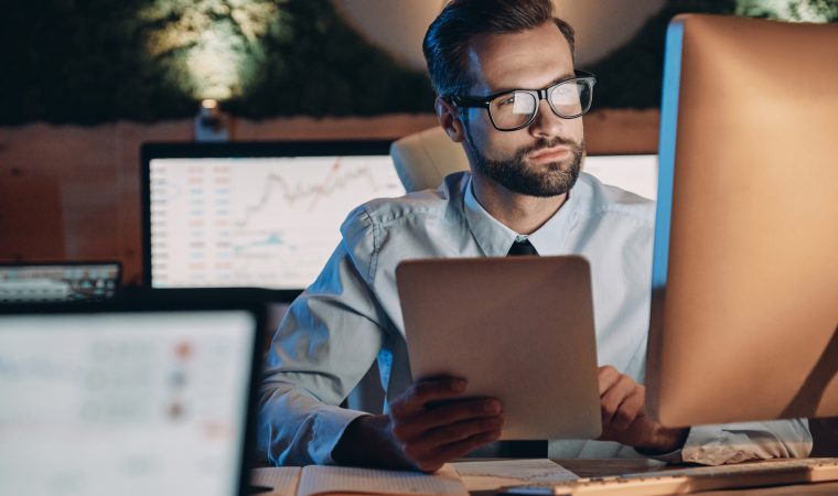 Confident young man working on computer while staying late in the office